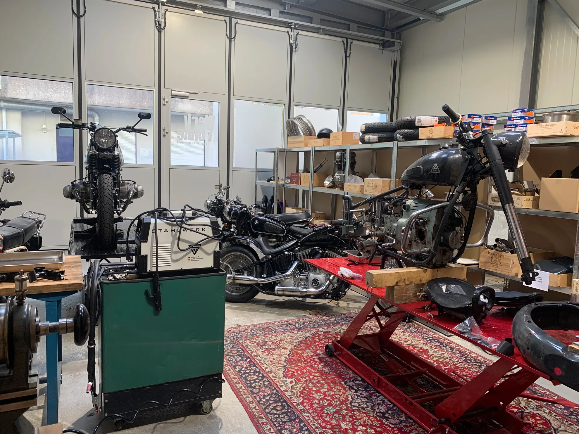 Workshop interior with motorcycle lifts and vintage motorcycles